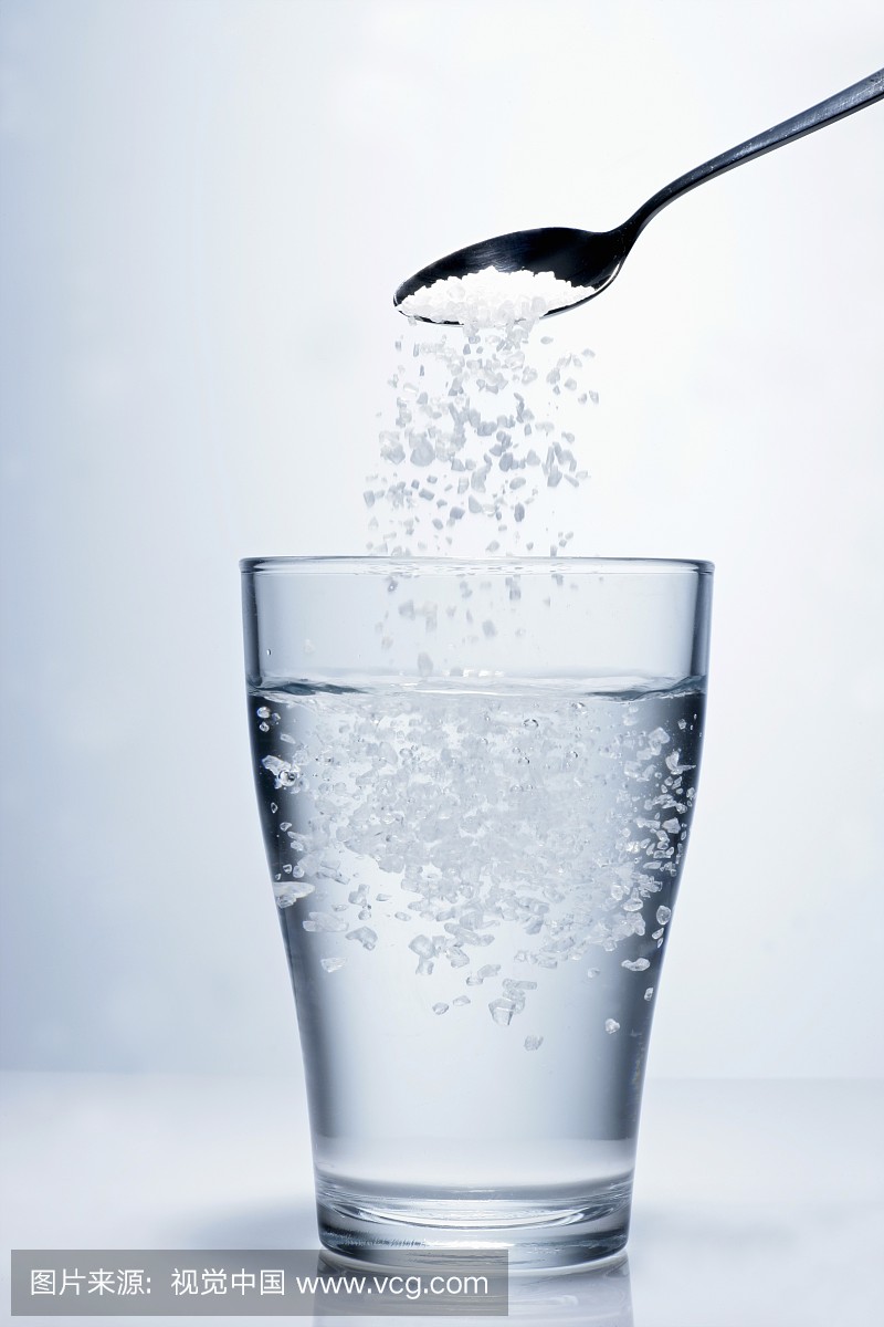 Sprinkling salt into a glass of water