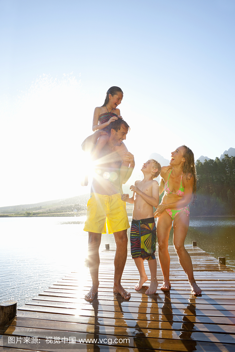Family standing on wooden dock at lake