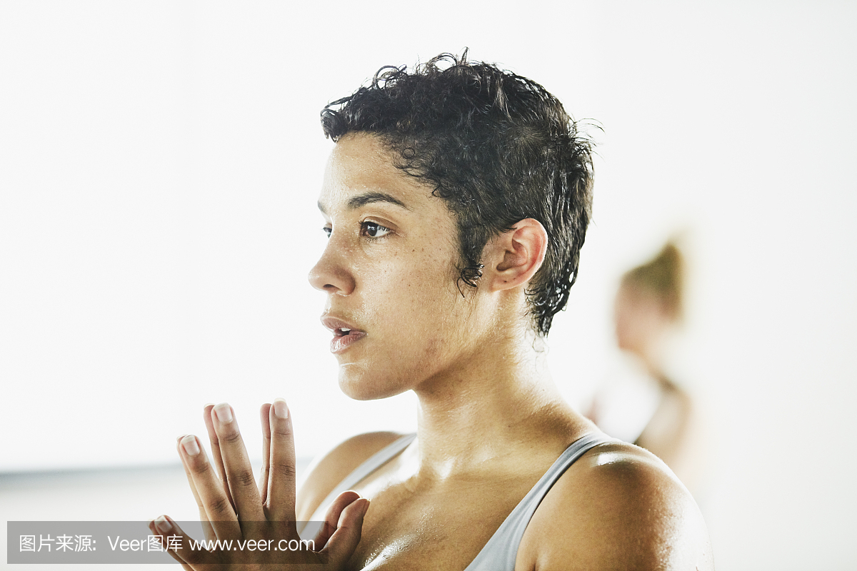 在锻炼室采取热瑜伽类的出汗的妇女