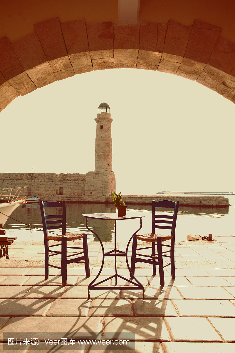 老复古咖啡馆和灯塔在海上Rethymnon克里特岛