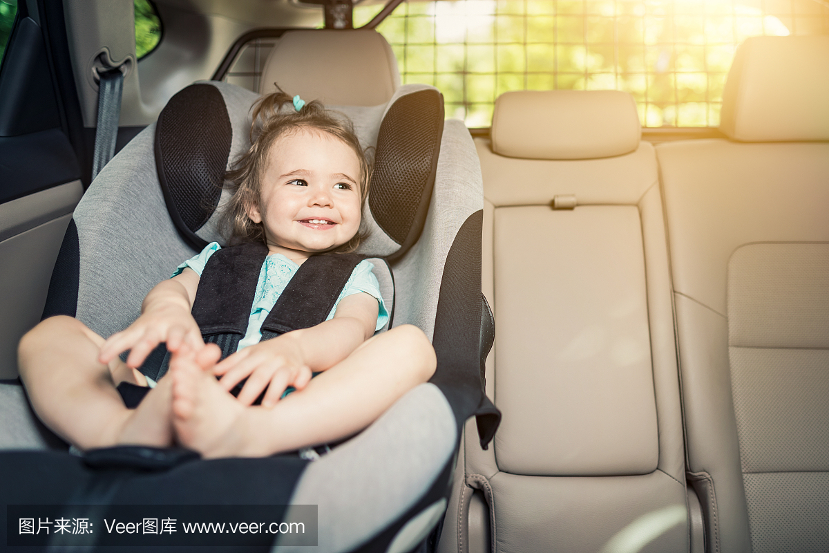 婴儿女婴扣在她的汽车座椅上。