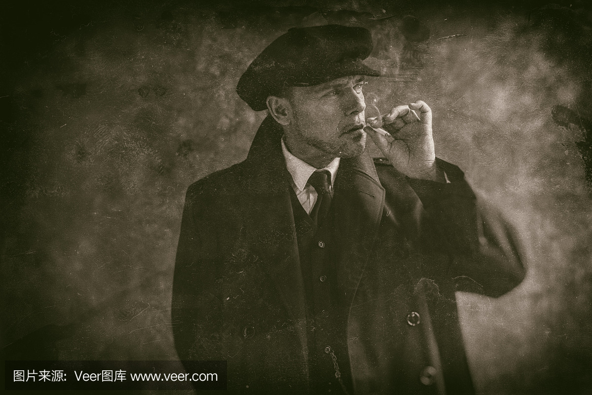 20世纪20年代英语流氓黑烟吸烟。穿黑色外套