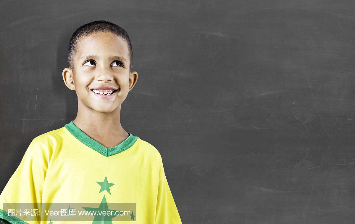 开朗的微笑的孩子在黑板上。学校概念