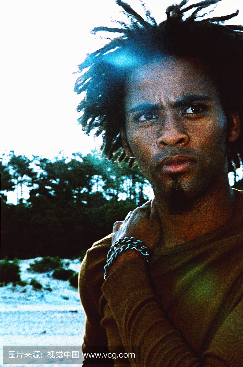 一个站在户外的年轻人用手放在他的肩上的特写