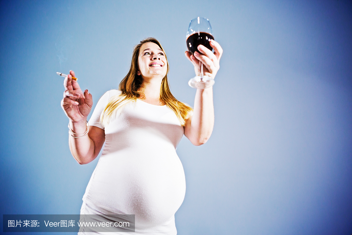 非常怀孕的女人吸烟和烤酒