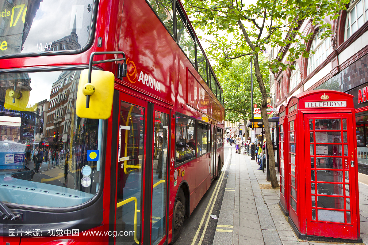 一个明亮的红色双层巴士停在一对标志性的红色