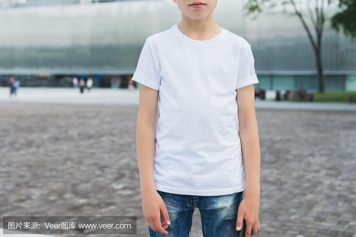 年轻的时髦男孩穿着白色t恤站立室外。小样。