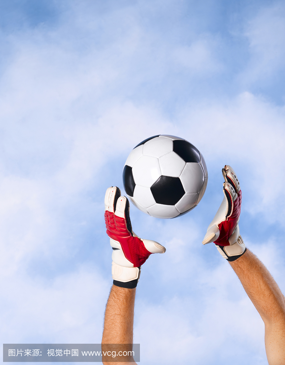 守门员抓住对天空的足球,手和手臂的特写