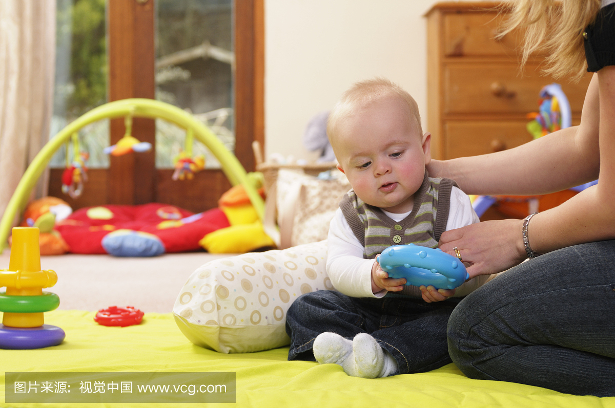 六个月大的婴儿在坐着和玩耍时得到支持