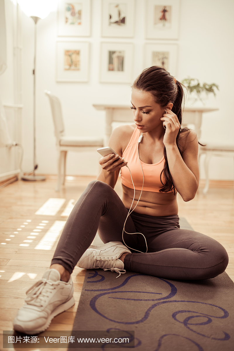 调整耳机的运动员,准备用音乐锻炼身体。