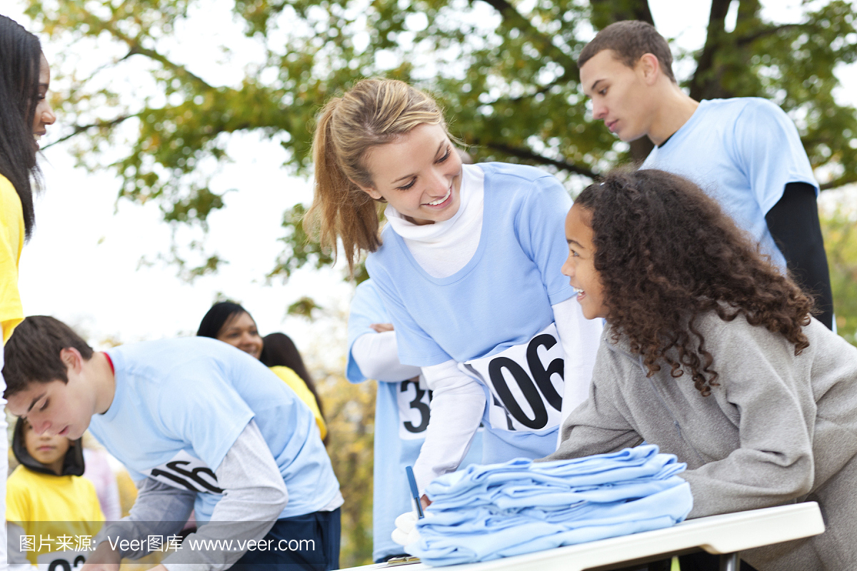 青少年志愿者帮助小女孩注册慈善比赛