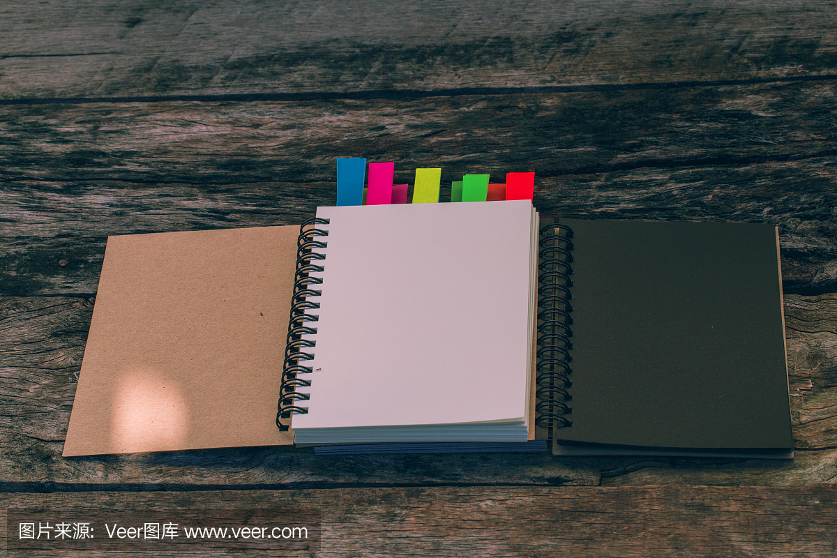 最小的工作空间:空白笔记本与旧木桌上的颜色