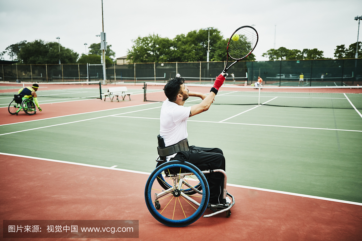 在为轮椅网球比赛热身时,自适应运动员练习发球