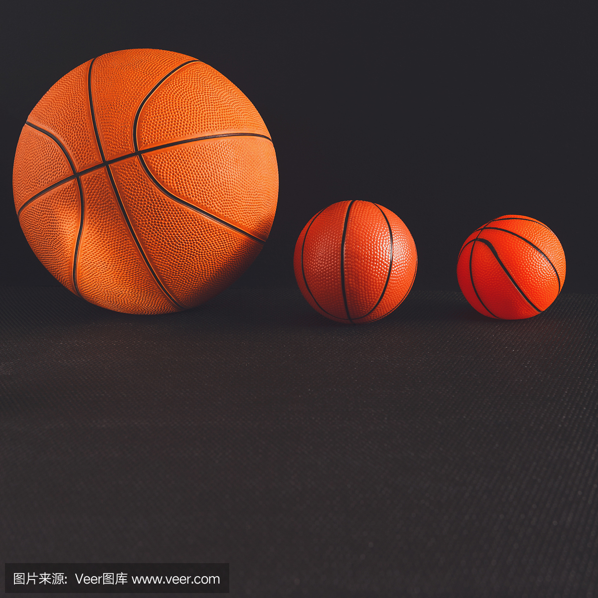 在黑色背景上的大和小篮球球