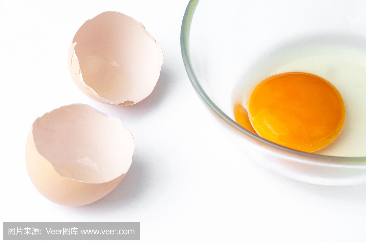 蛋壳和生鸡蛋蛋黄在白色背景隔绝的玻璃特写镜头