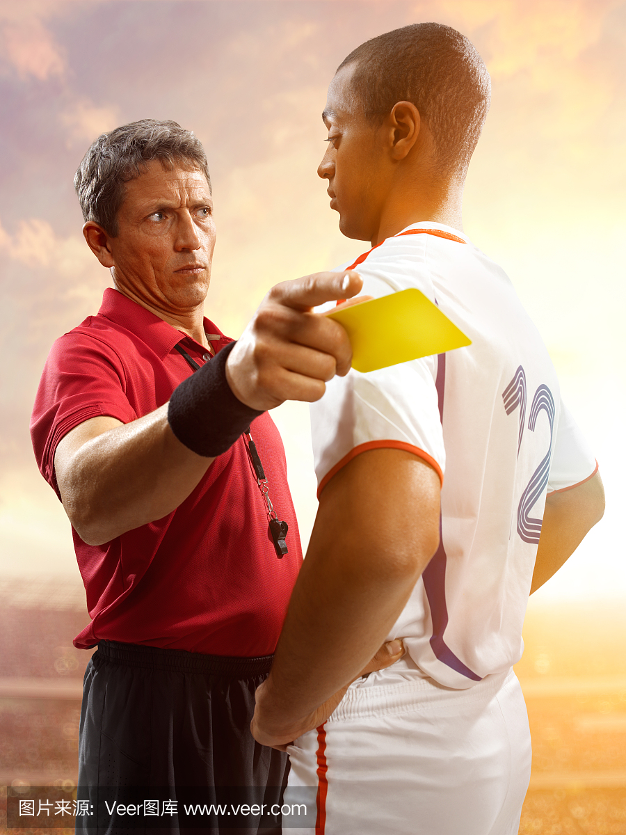 足球裁判员向足球运动员显示黄牌