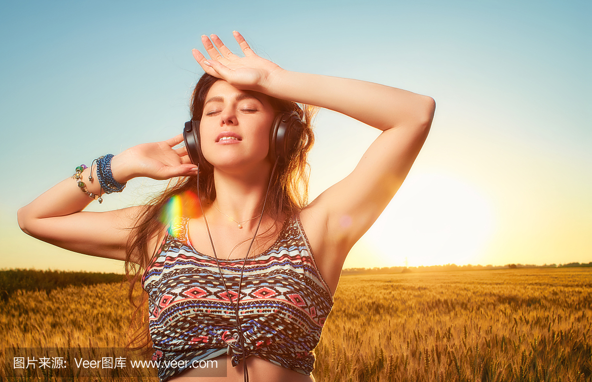 休息的年轻运动女子闭上眼睛,用耳机听音乐