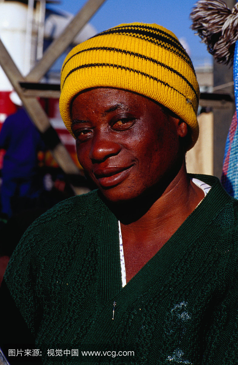 在Mbare市场上的一个黄色针织帽子的女人肖像