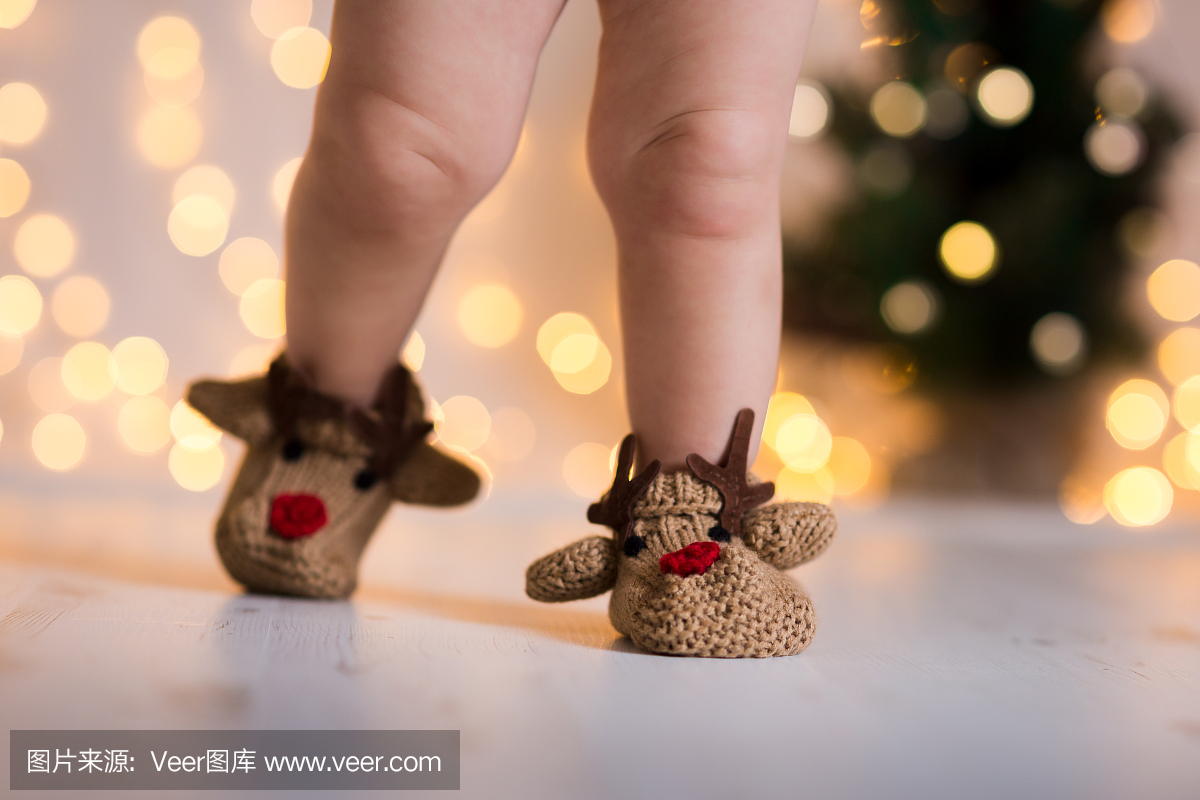 圣诞节主题婴儿的腿在针织节日鹿像靴子
