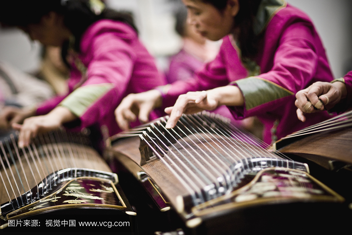 一组古筝玩家用手指来控制每个音符的音调和颤