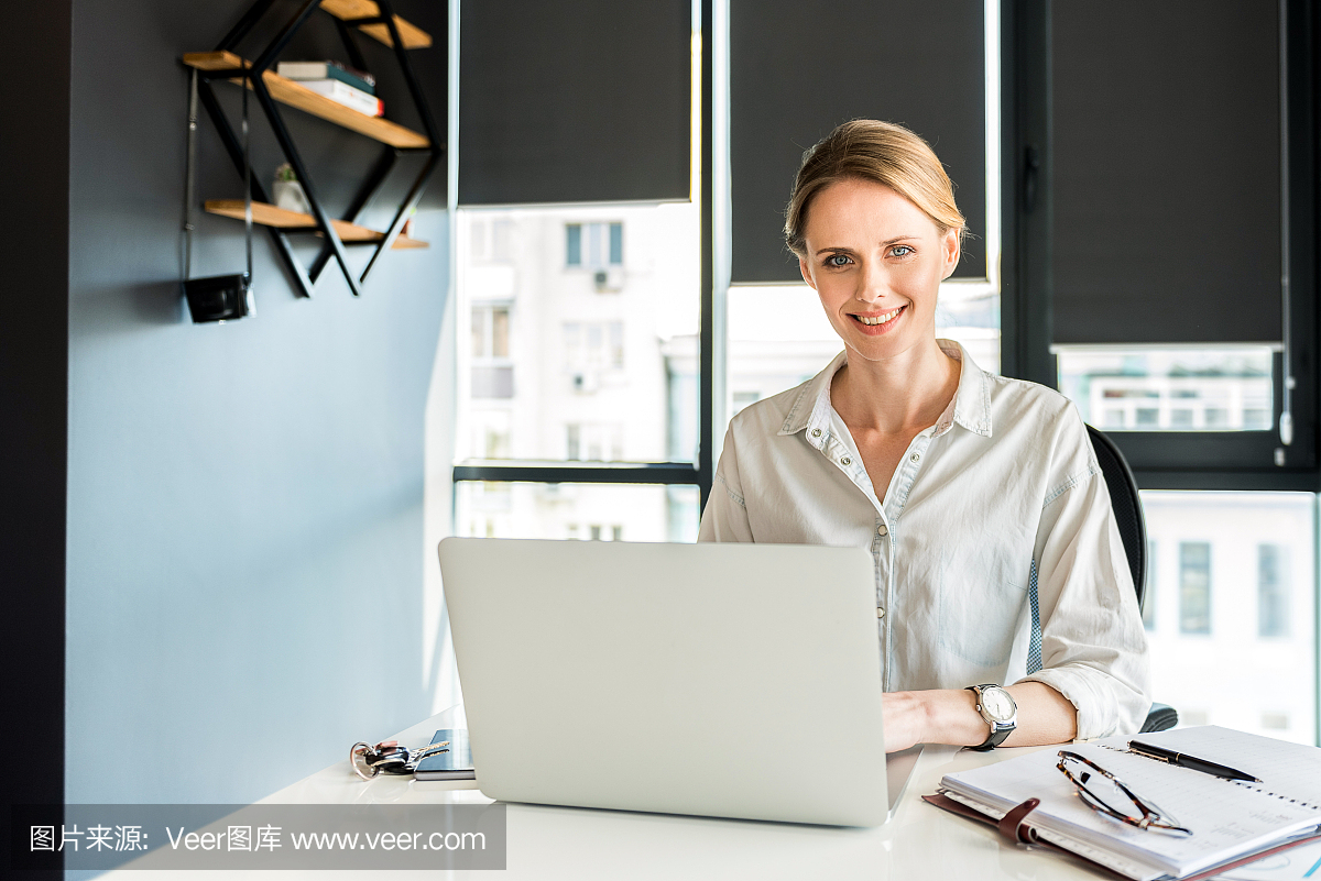 雄心勃勃的迷人女士在笔记本上打字微笑