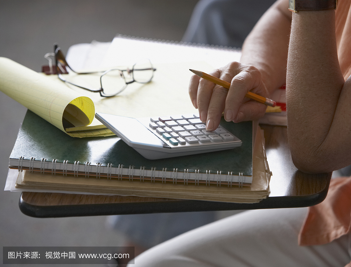 高级女子使用计算器,特写镜头