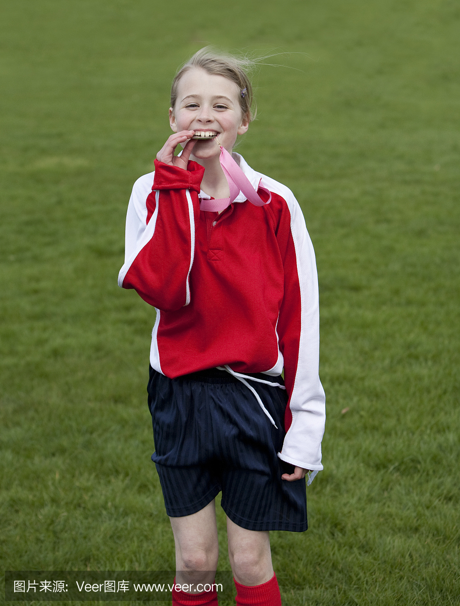 年轻女子足球运动员'测试'她的金牌奖牌