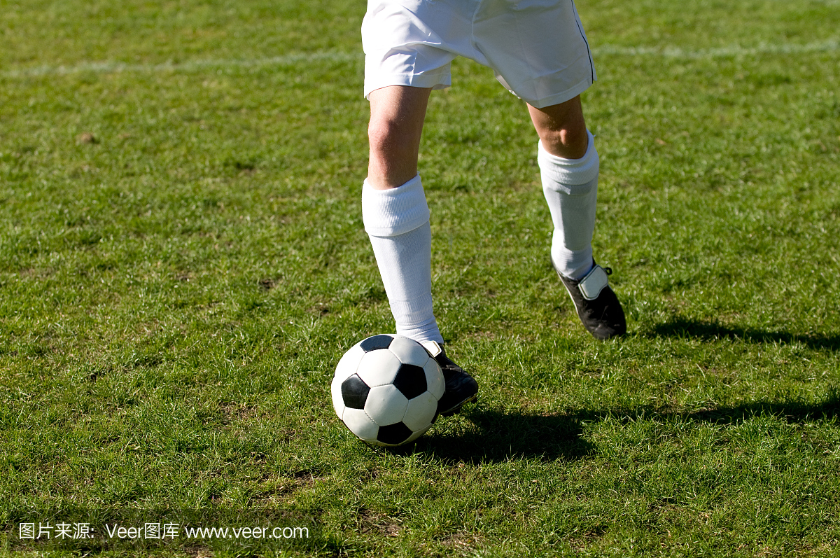 足球运动员跑得很快,球附在他的脚上