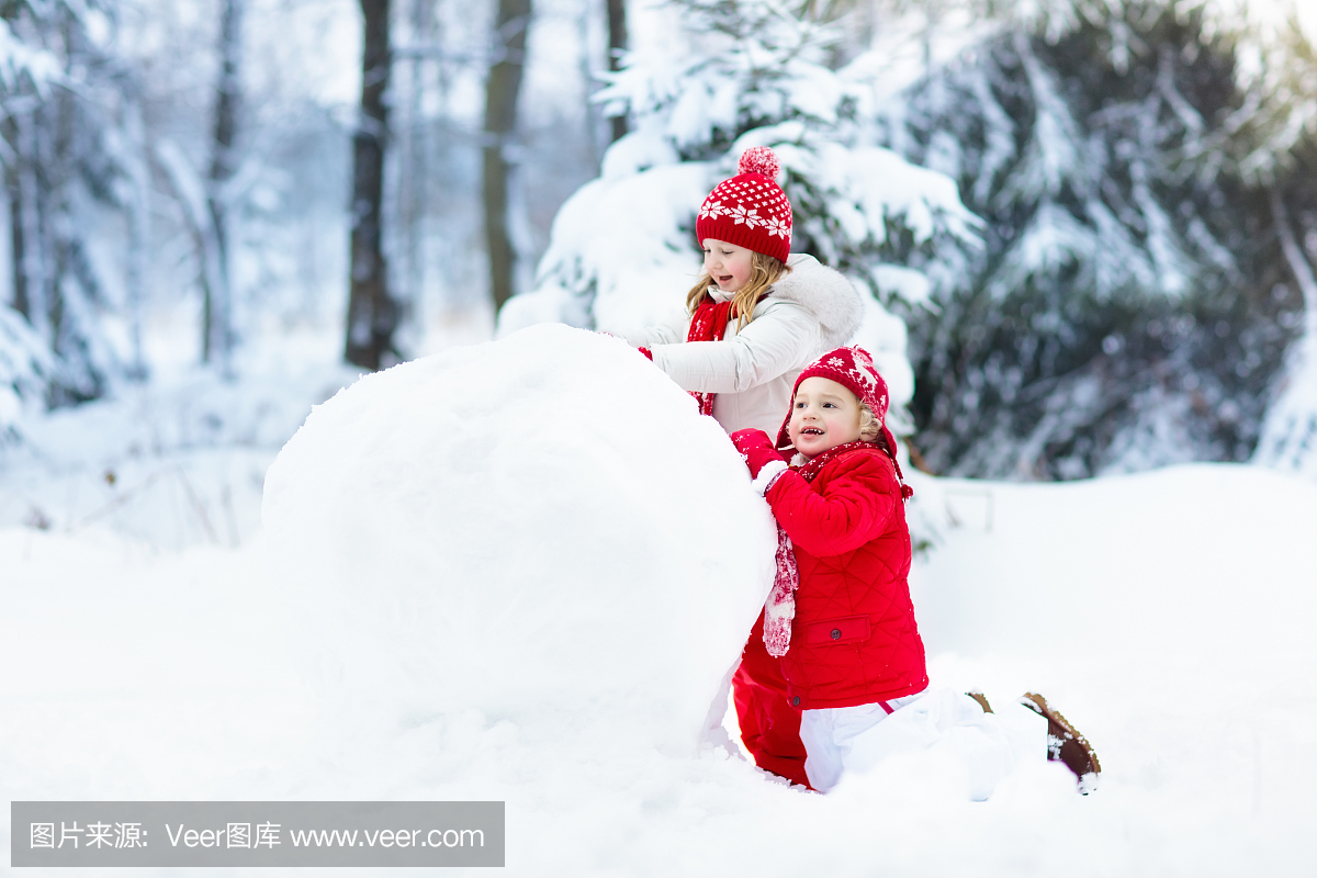 孩子们建立雪人。雪中的孩子。冬天的乐趣。