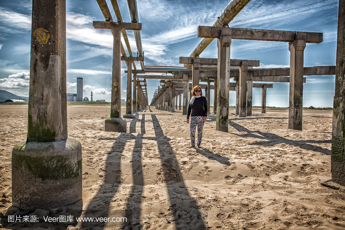 成熟的西班牙裔妇女站在工业海滩