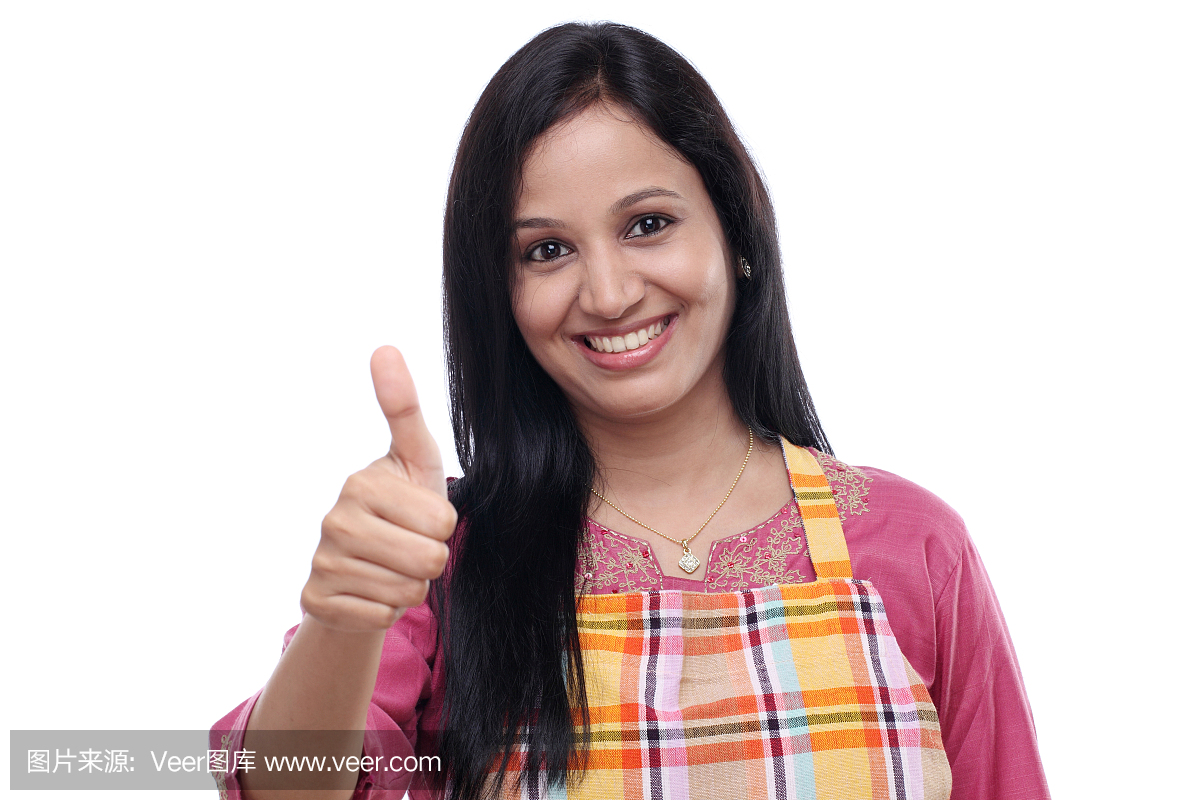 快乐的年轻印度女人穿着厨房围裙
