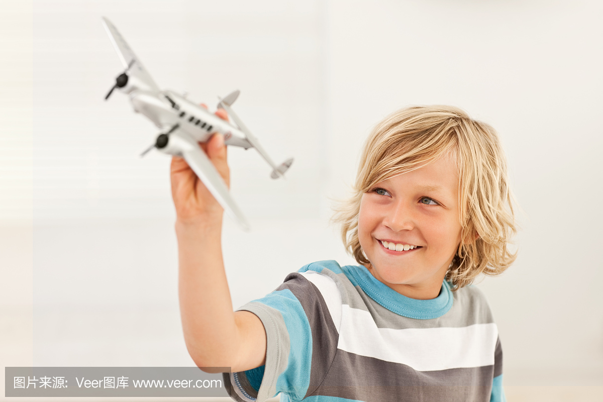 快乐的男孩玩玩具飞机