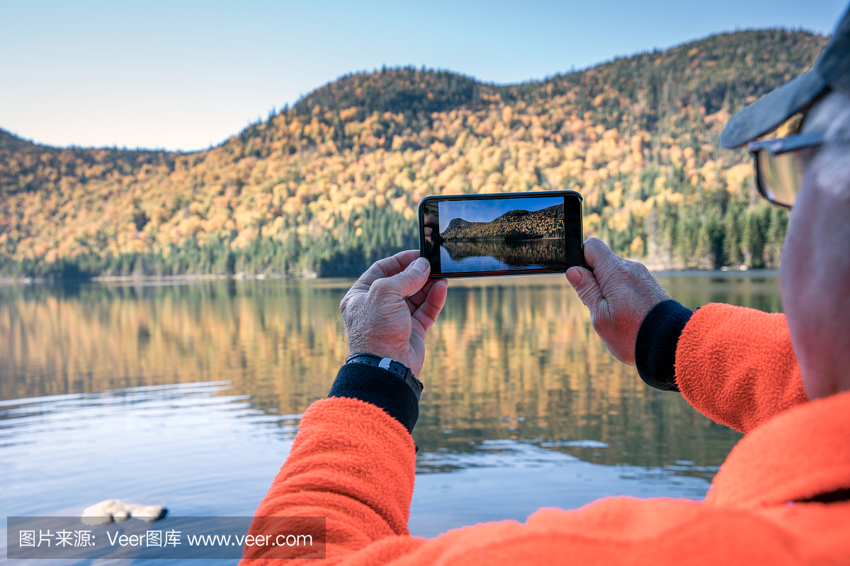 老人用手机拍摄湖自然图片
