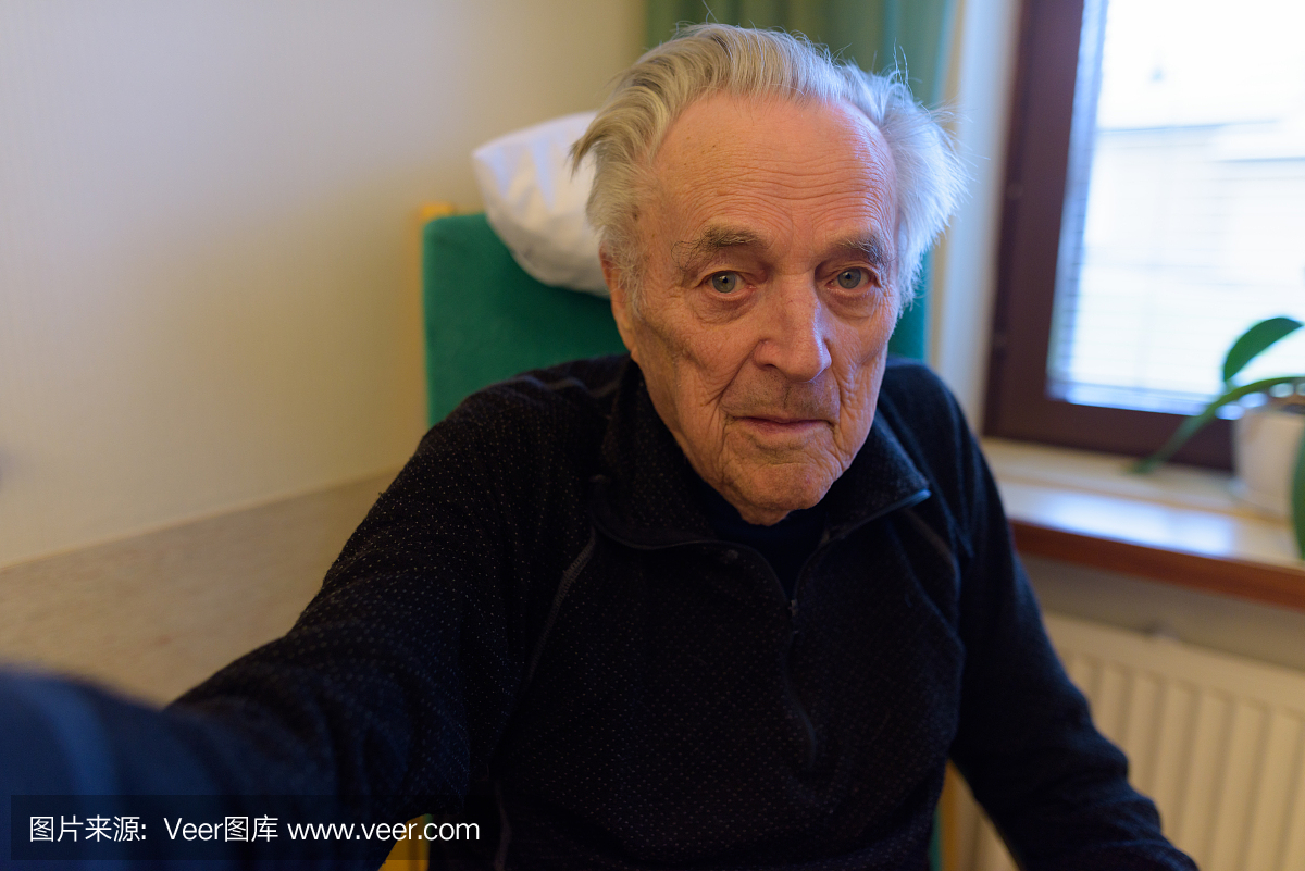 老人放松在窗口在芬兰图尔库疗养院