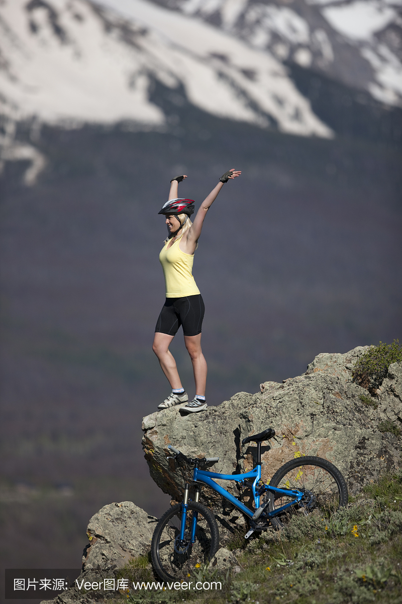 Female Celebrating Making Bike Climb to Mountain Top