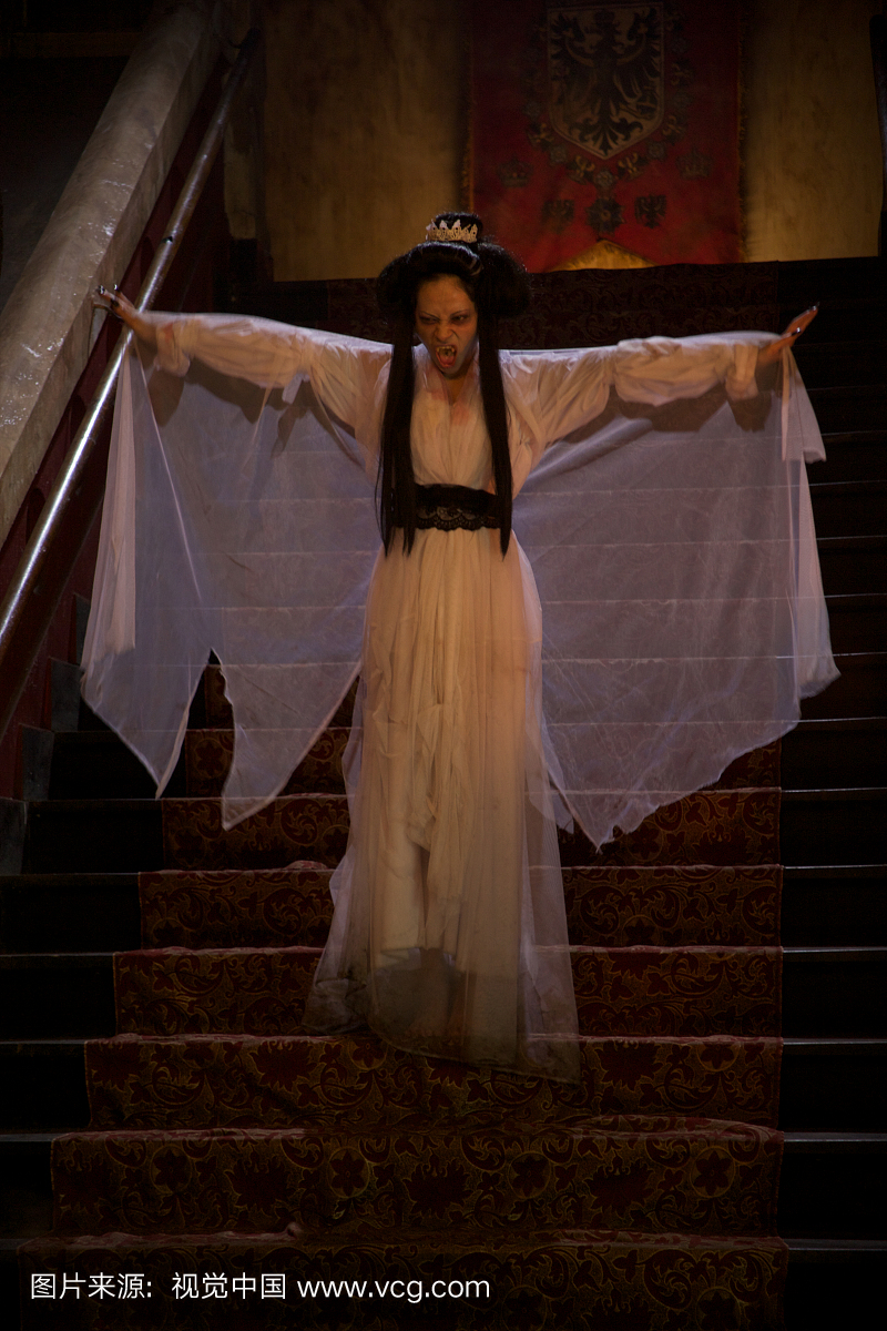 一个吸血鬼新娘站在城堡里的一个staicase展示