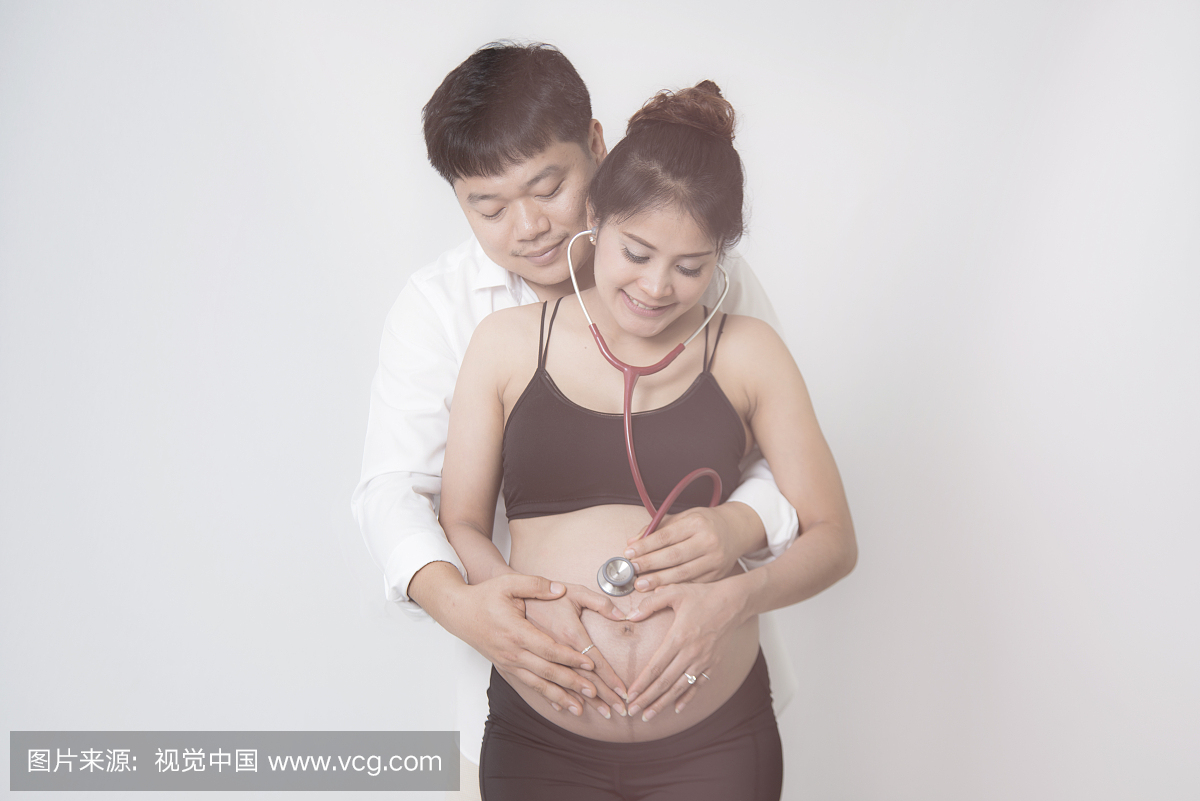 与孕妇母亲和丈夫的父亲的亚洲家庭通过使用听