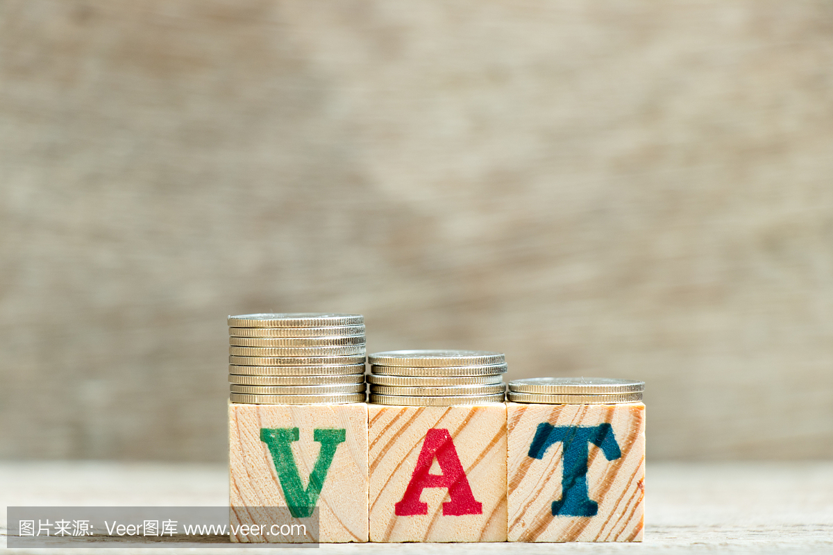 在字样增值税(增值税的缩写)与硬币在木材背景