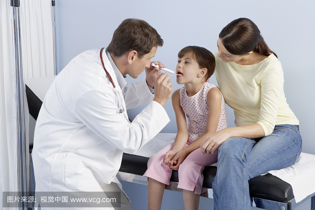 医生使用舌抑制剂来检查小男孩的喉咙