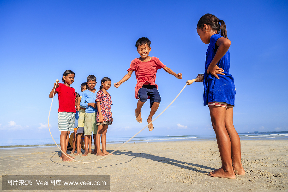 小组柬埔寨孩子们在沙滩上玩跳绳,柬埔寨