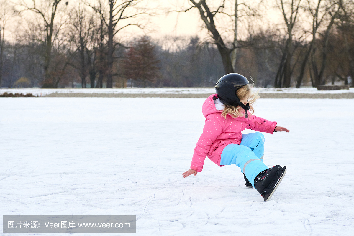 快乐的小女孩,在户外冬季滑冰,戴着安全帽