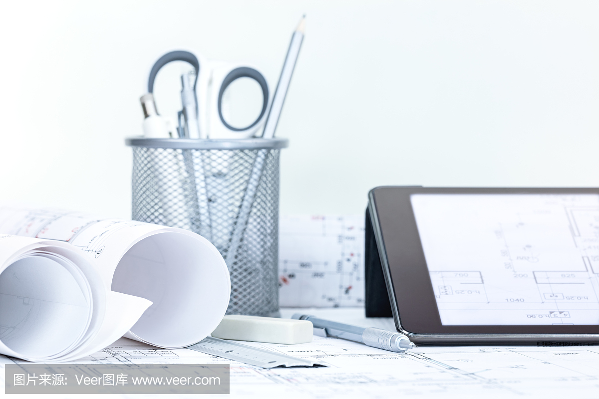 建筑图纸与平板电脑在桌上滚动羊皮手套样板设计图纸图片
