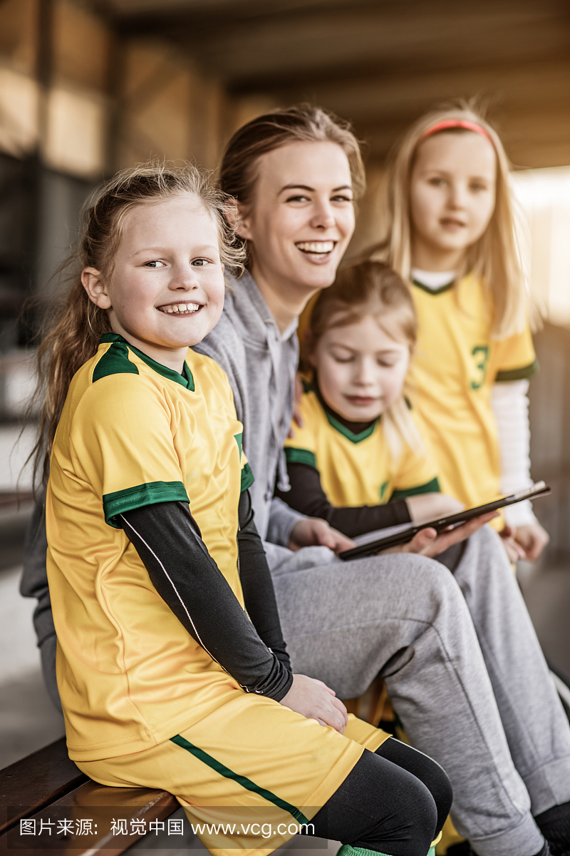 年轻的金发女子足球教练和她的女孩足球队