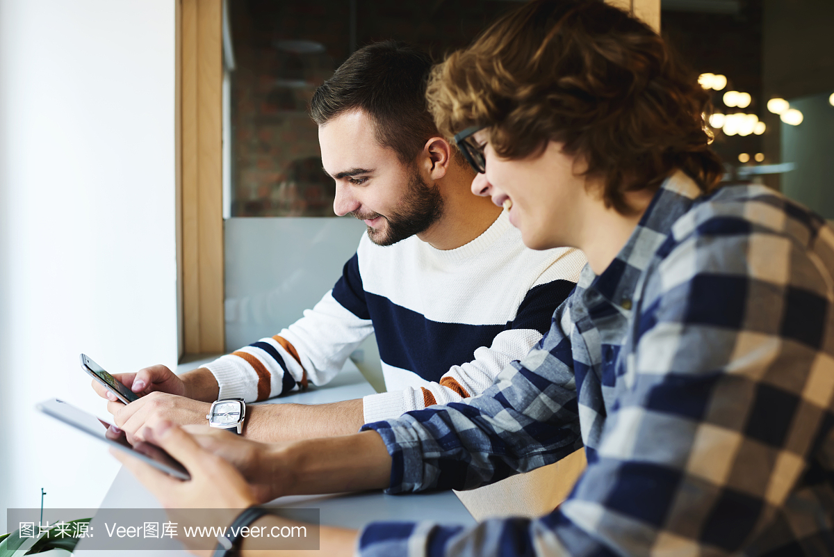 开朗的青少年朋友花时间在一起通过现代的小工