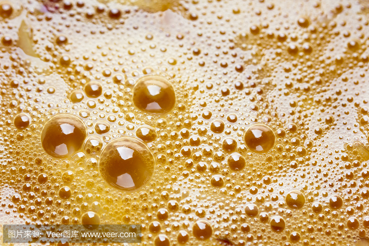 关闭了抽象的橙色背景的新鲜殴打鸡蛋蛋黄表面