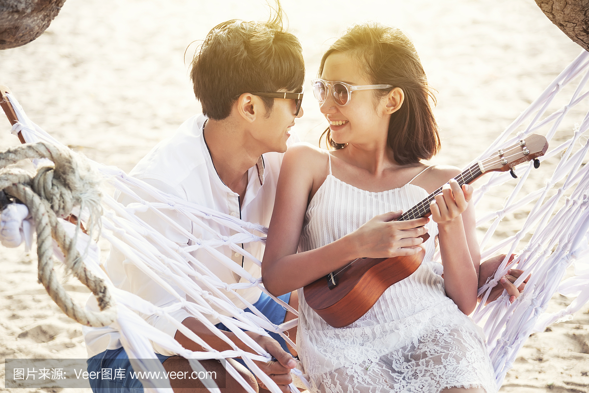 幸福情侣在夏季时间玩夏威夷四弦琴。