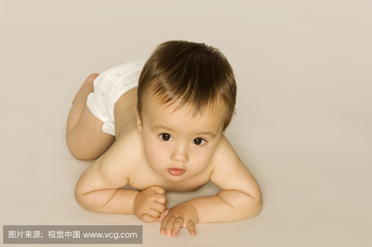 婴儿(6-9个月)在地板上爬行。肖像