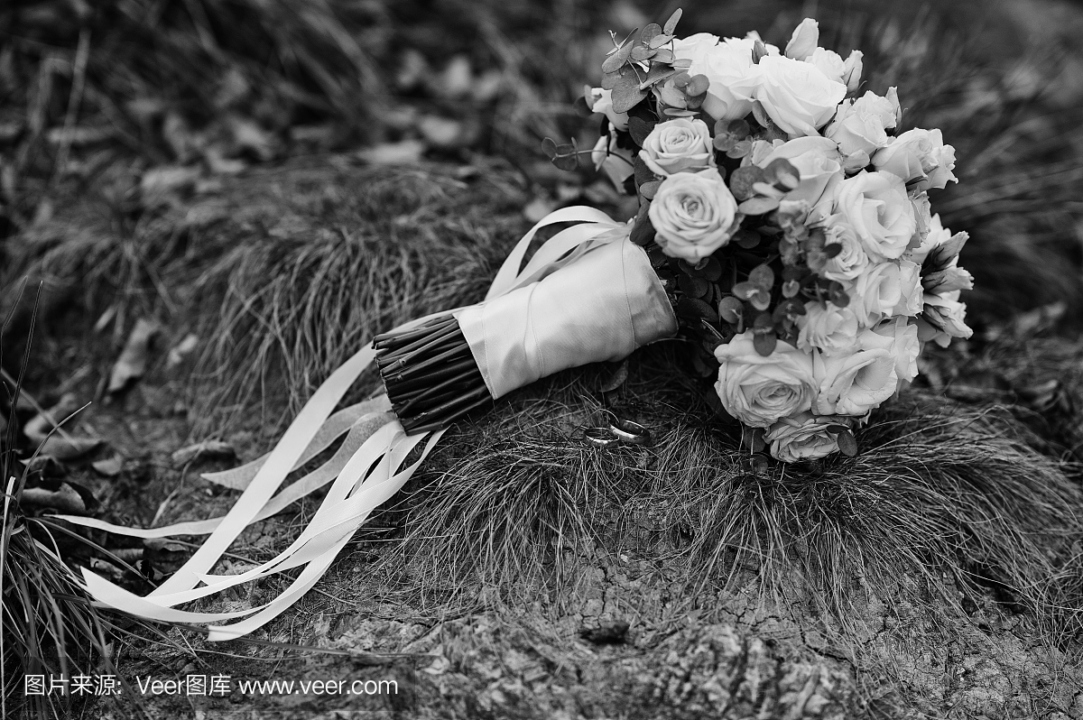 用白色丝带在草地上的婚礼花束。