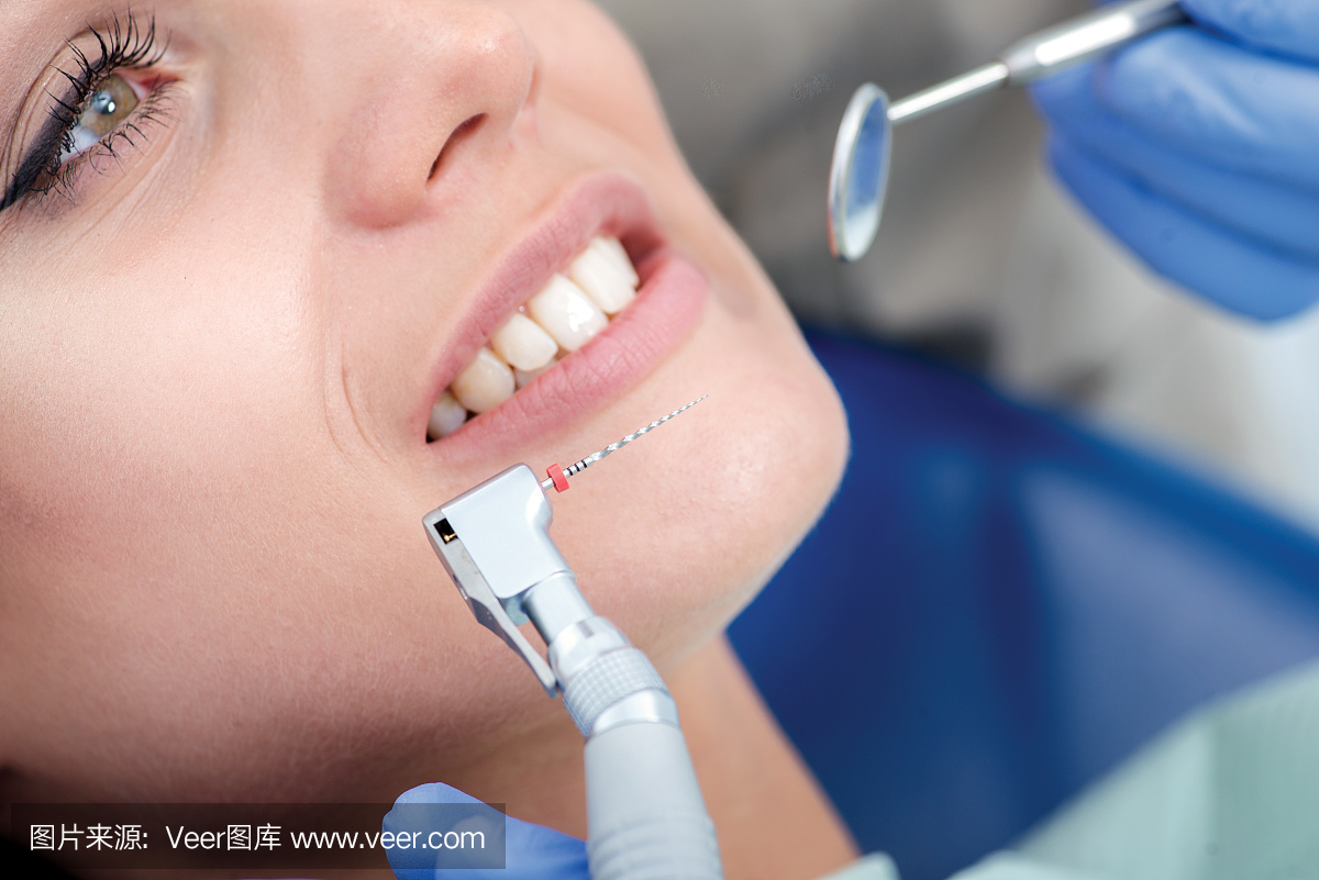 牙科钻头附近女子的笑容。牙医做过程