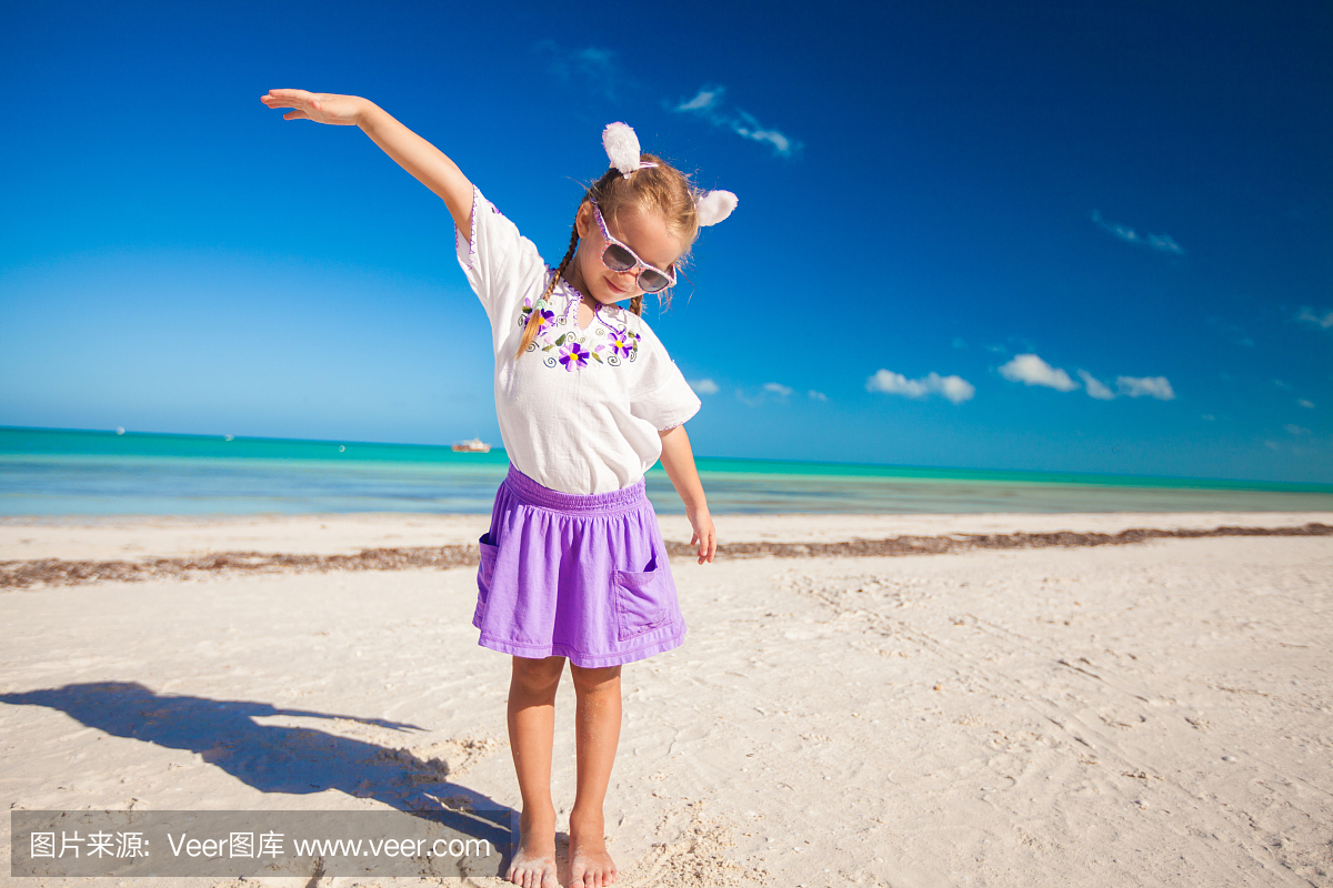 可爱的小女孩在异国情调的海滩上的复活节服装